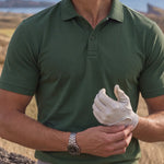 Close-up of the Deep Cypress Biome polo collar and chest as a golfer adjusts a white glove.