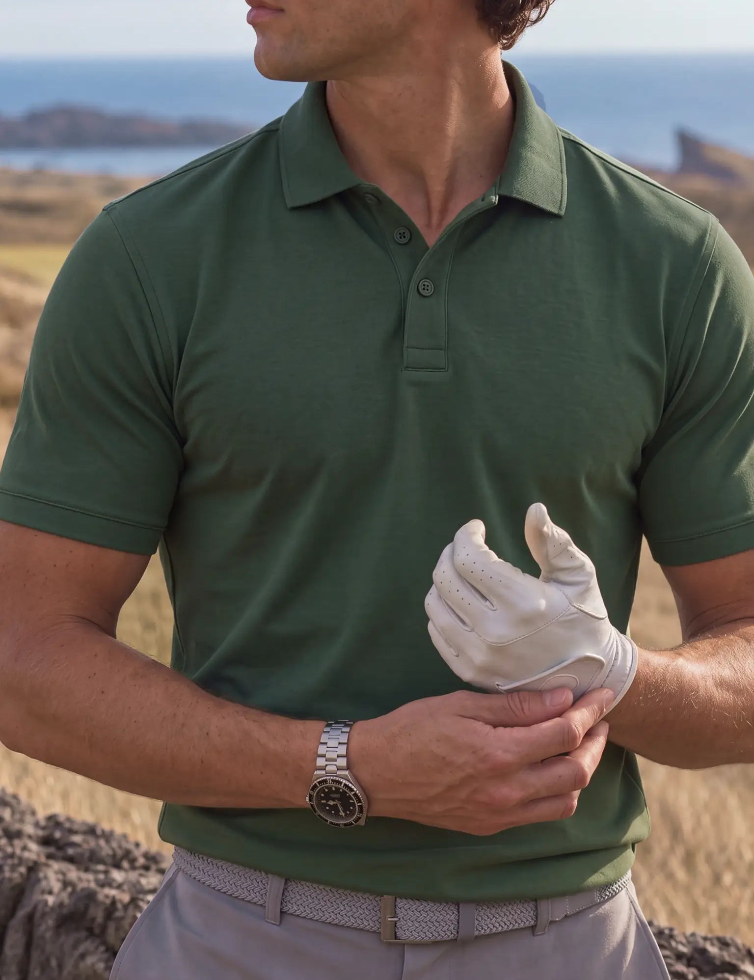 Close-up of the Deep Cypress Biome polo collar and chest as a golfer adjusts a white glove.