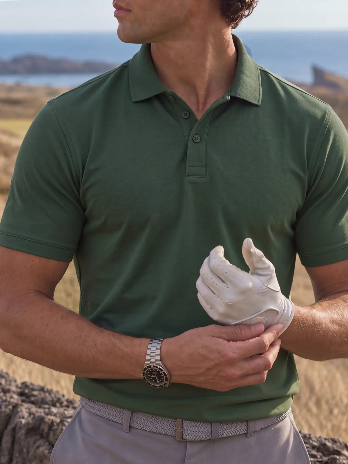 Close-up of the Deep Cypress Biome polo collar and chest as a golfer adjusts a white glove.