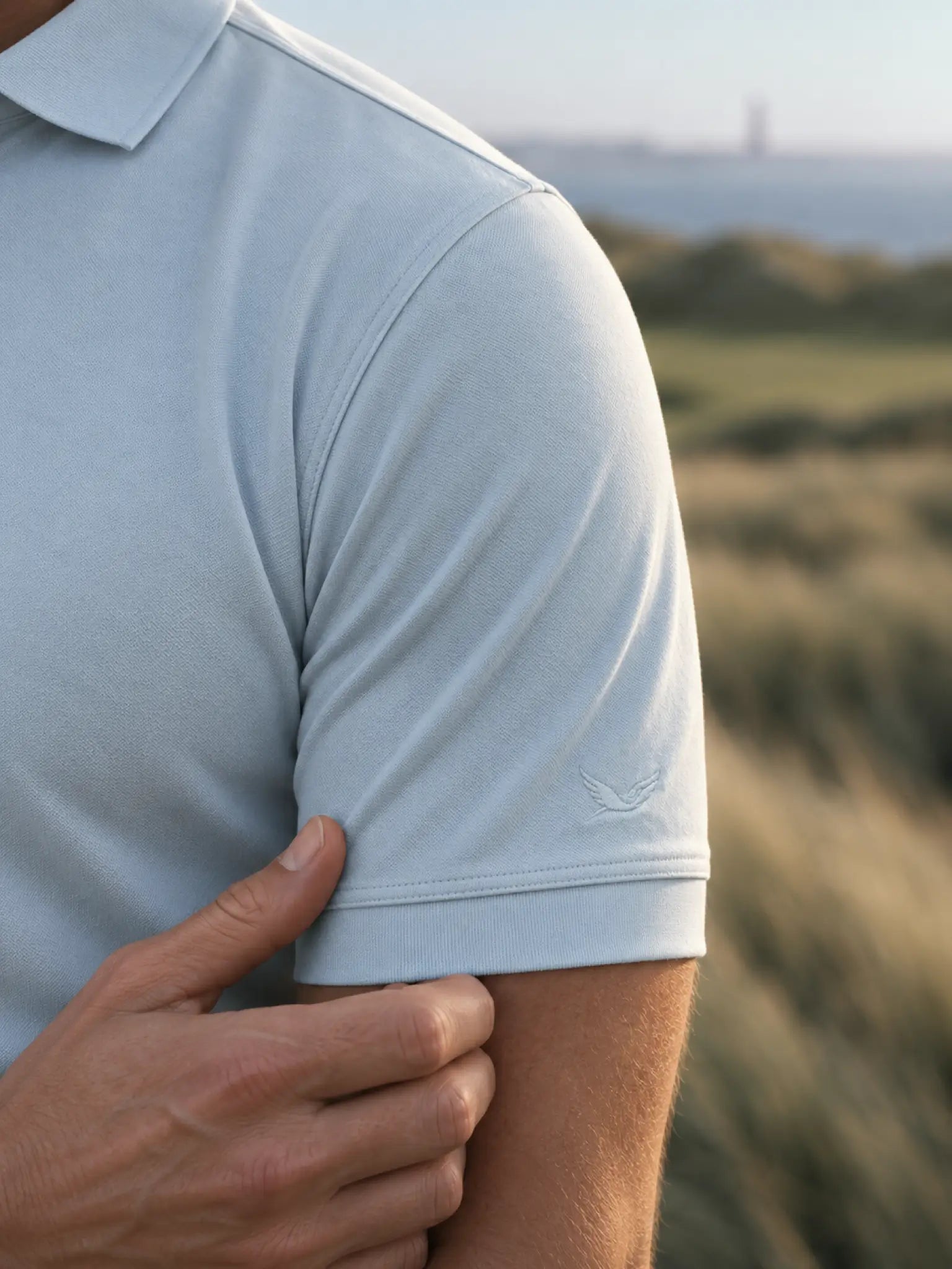 Close-up of the Glacier Biome polo short sleeve and pale blue jersey fabric.