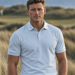 Front view of a golfer wearing the light blue Glacier Biome polo with gray trousers.