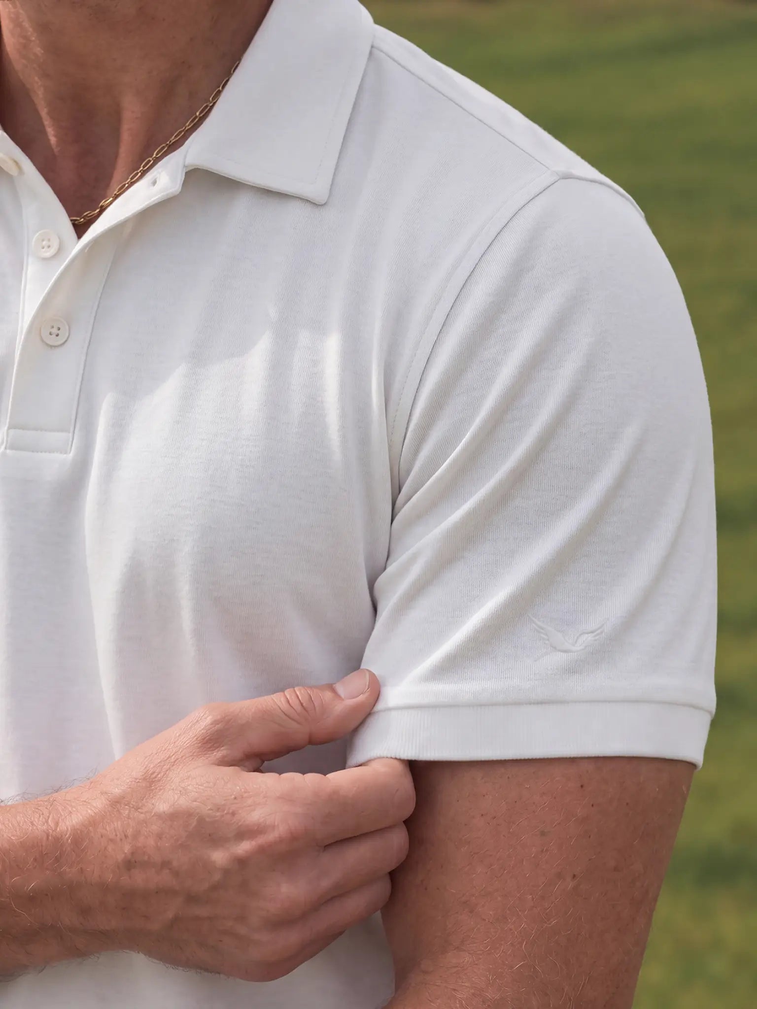 Close-up of the Limestone Biome polo sleeve and chest, showing its off-white jersey texture.